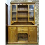 A stripped and waxed pine kitchen dresser, the base partially enclosed by a pair of panelled doors