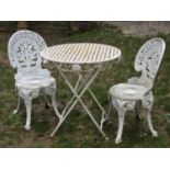 A pair of painted and weathered cast aluminium garden terrace chairs with decorative pierced