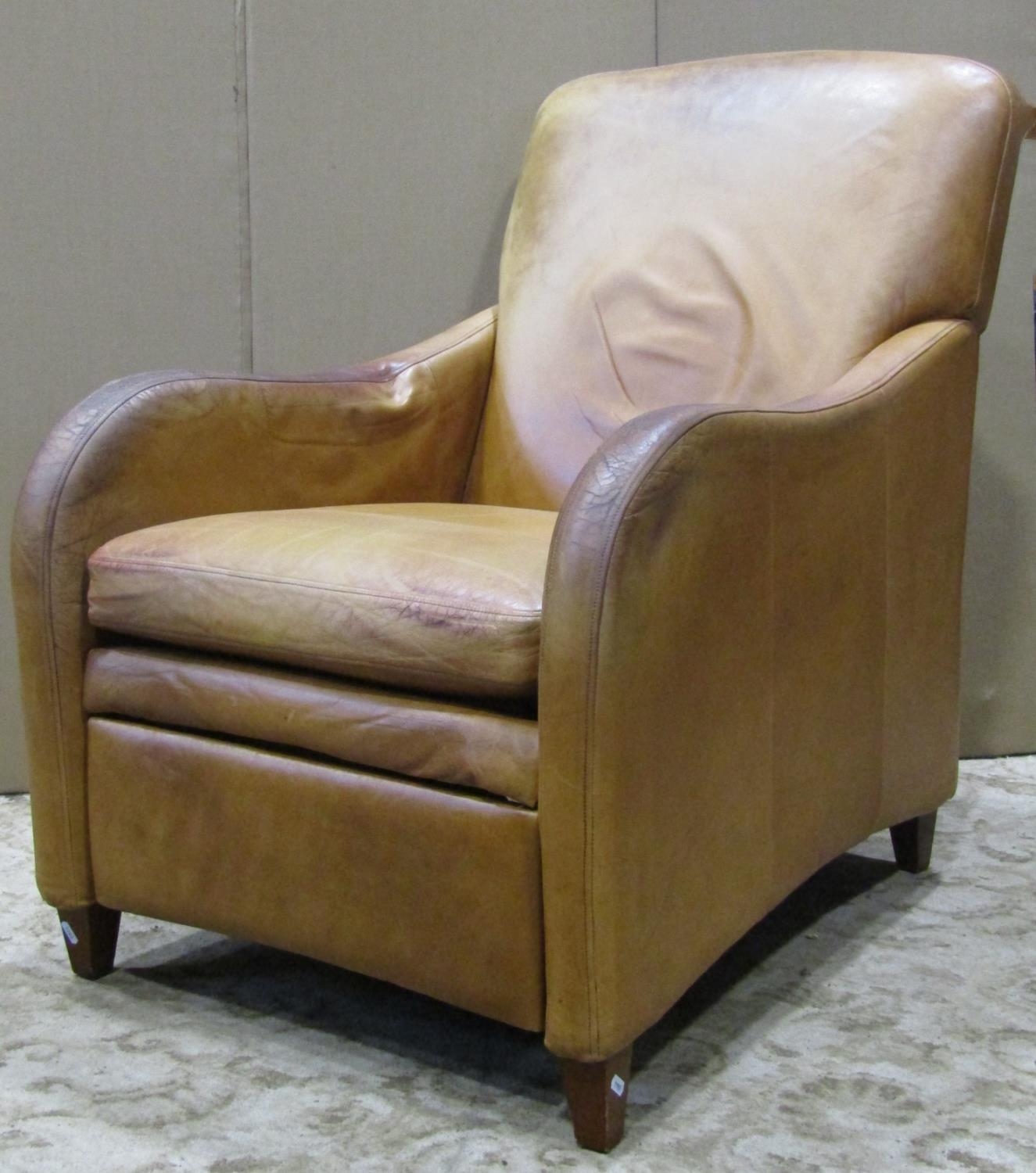 A soft stitched leather upholstered reclining armchair raised on square taper supports