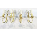 Set of four cast brass wall lights with scrolled backs, hung with cut glass drops