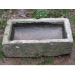 A small weathered rectangular trough with dished interior, 54 cm long x 36 cm wide x 15 cm deep