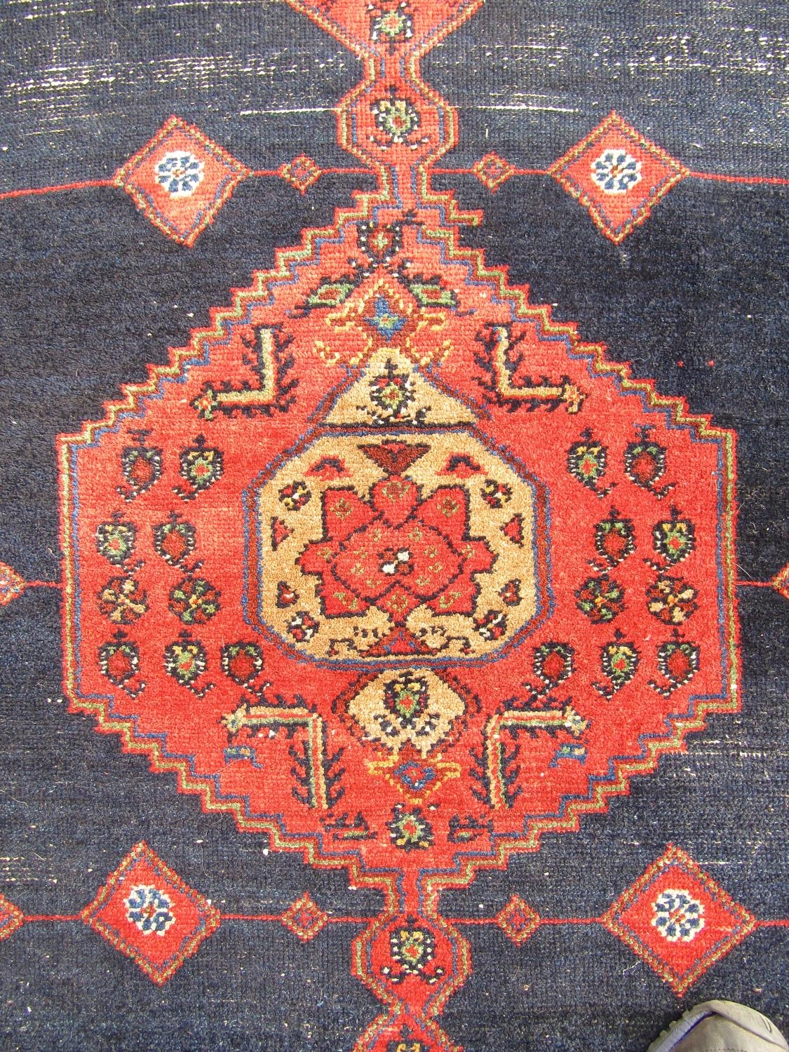 An old Kazak carpet with a central extended medallion and stylised flowers on a dark blue ground, - Image 2 of 4