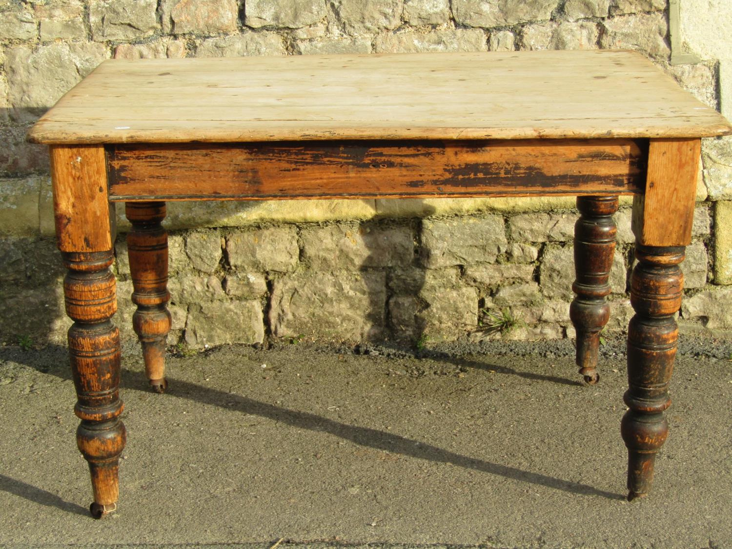 A late Victorian scrubbed pine kitchen table raised on turned supports (lacks frieze drawer, AF) 4ft