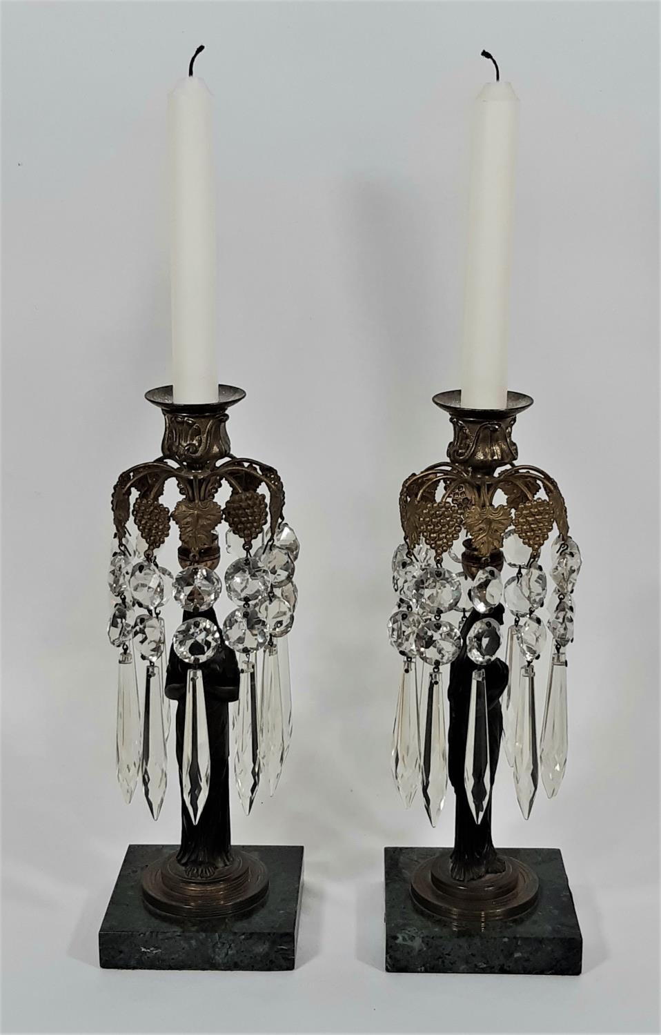 A pair of Regency table candlesticks decorated with ten gilt vine and grape fronds hung with glass