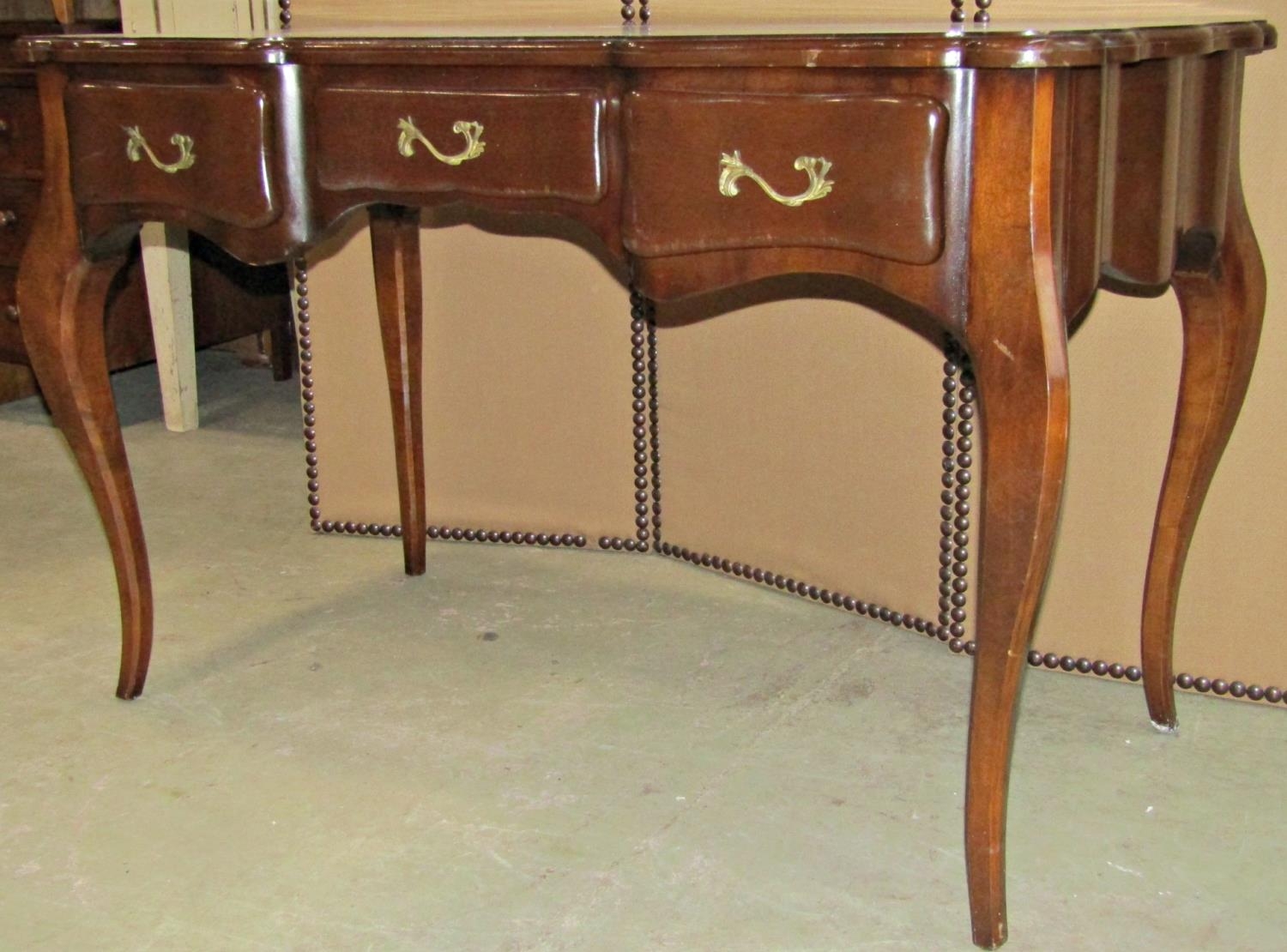 A reproduction bureau plat with serpentine moulded outline over three frieze drawers, 122 cm wide