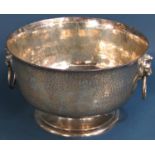 A good hammered silver presentation bowl with lion mask and ring handles raised on a turned foot