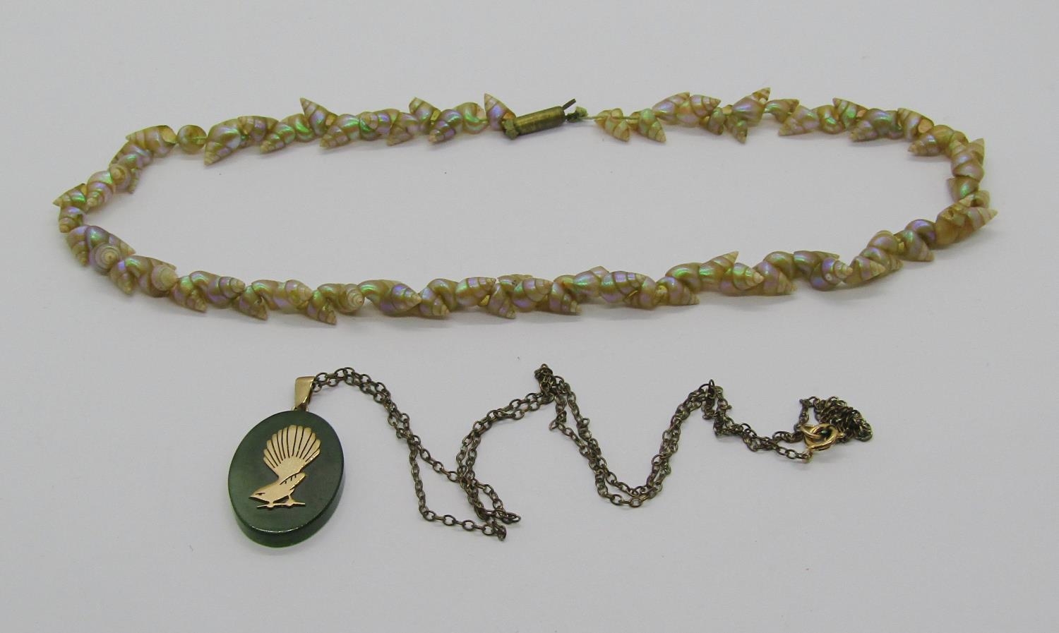 Nephrite pendant with applied yellow metal fantail bird, together with a Tasmanian Maireener shell