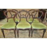 A set of six Victorian walnut balloonback dining chairs with moulded frames upholstered seats and