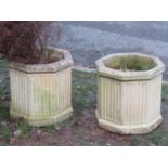 A pair of weathered cast composition stone garden planters of octagonal form with fluted detail,