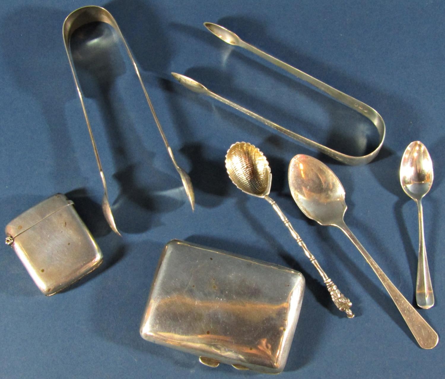 A small selection of various teaspoons, two sugar tongs, a cigarette case, and a vesta , 6.9oz