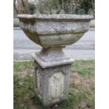 A weathered cast composition stone garden planter of square tapered form with rose banded relief