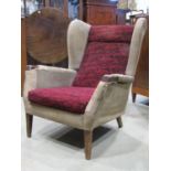 A mid 20th century wing armchair made by Christie Tyler, Bridgend, Glamorgan, (af) for re-upholstery