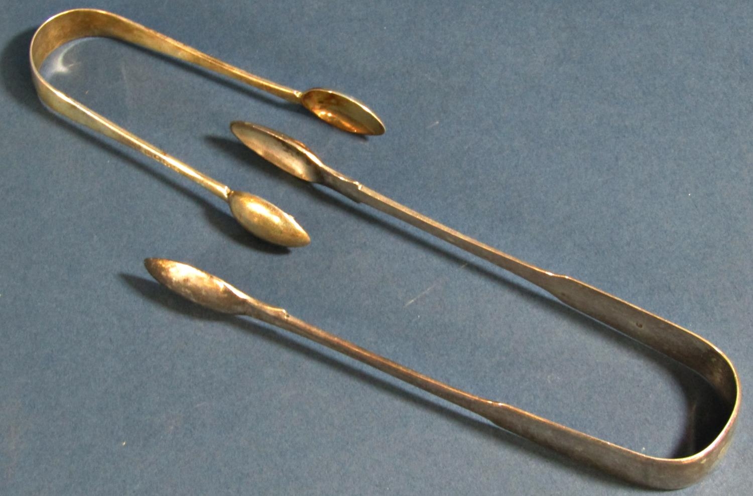 Three silver casting spoons (two Georgian) and two pairs of sugar tongs, 5 oz - Image 4 of 4