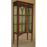 An Edwardian display cabinet with painted to simulate inlay detail, freestanding and enclosed by a