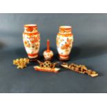 A pair of Imari baluster vases, 24cm high, another with slender neck, all on stands, a soapstone