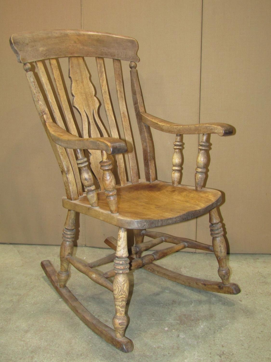 A Windsor stained elm and beechwood lathe back rocking chair with pierced fiddle splat