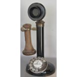 A vintage stick telephone with black enamelled column and copper ear piece