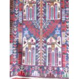 A Baluchi rug with four architectural panels in tones of red and blue, 141cm x 85cm approx.