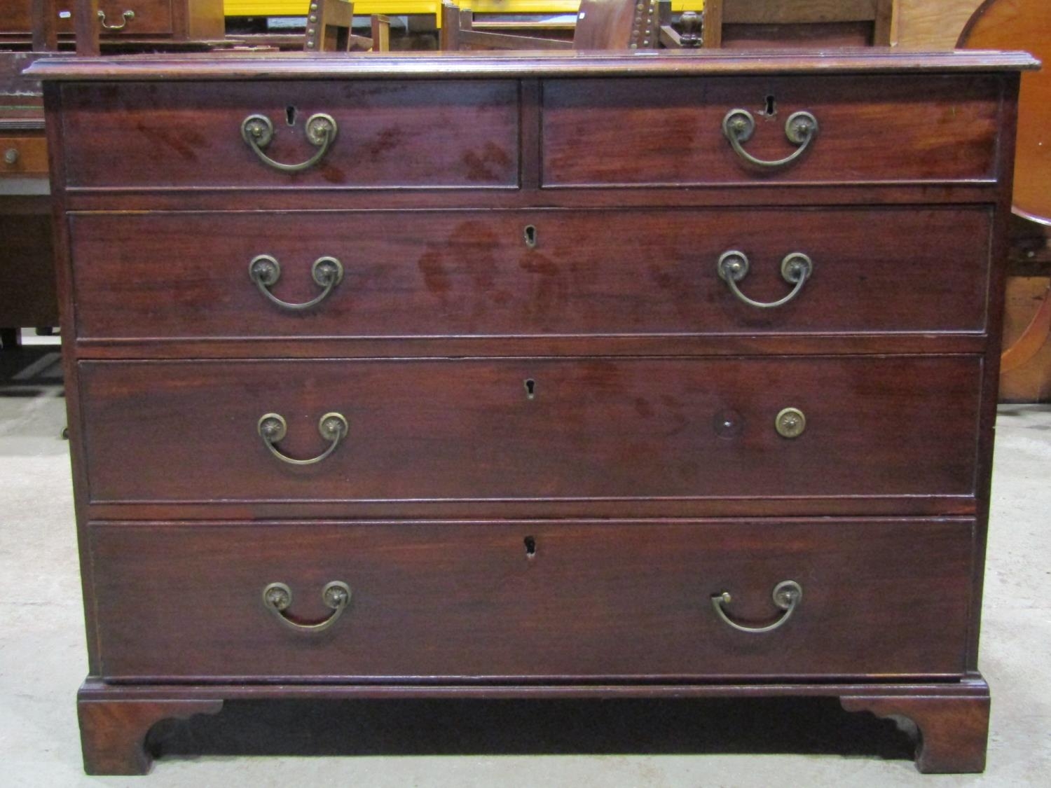 A Georgian mahogany bedroom chest of three long and two short graduated drawers set on bracket feet,