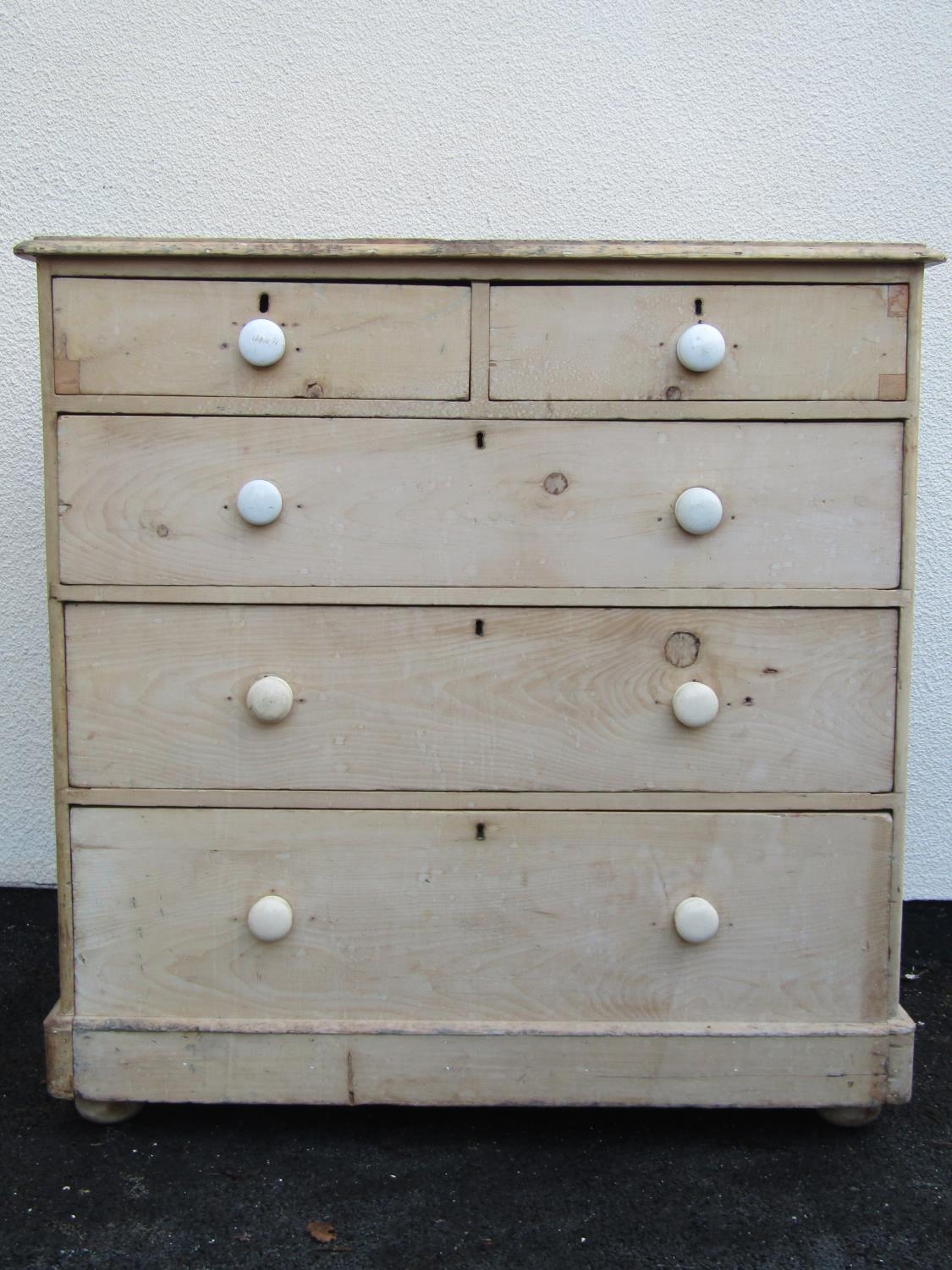 A stripped pine chest of three long and two short drawers on a plinth base 106 cm wide