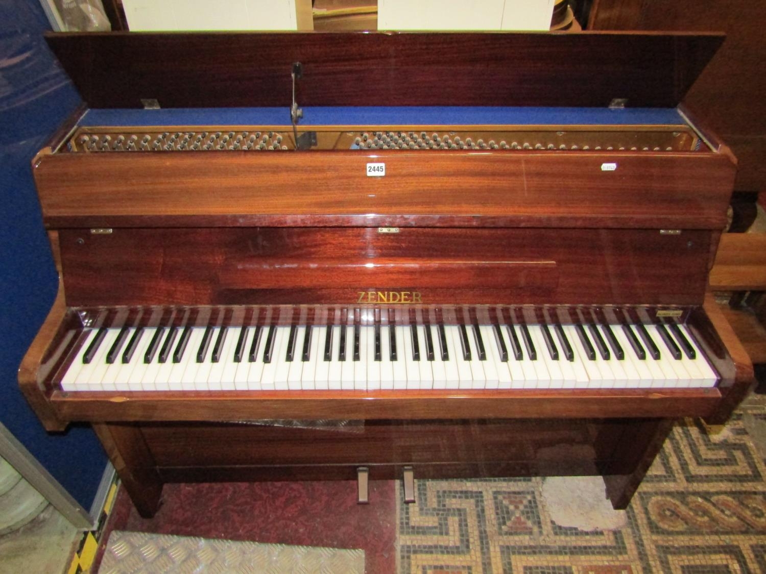 A Zender upright iron framed and overstrung piano in polished case stamped to iron frame MXB type