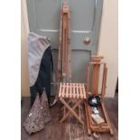 A plein air painter's collection of materials to include: Two compactable easels; a fold-up stool