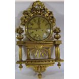 A gilded wall clock the decorative casework with column, floral and ribbon detail enclosing an eight