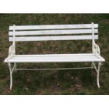 A painted two seat garden bench with timber lathes raised on pierced decorative cast metal end