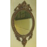 A Victorian gesso mirror, the bevelled edge mirror plate of oval form, the frame with repeating