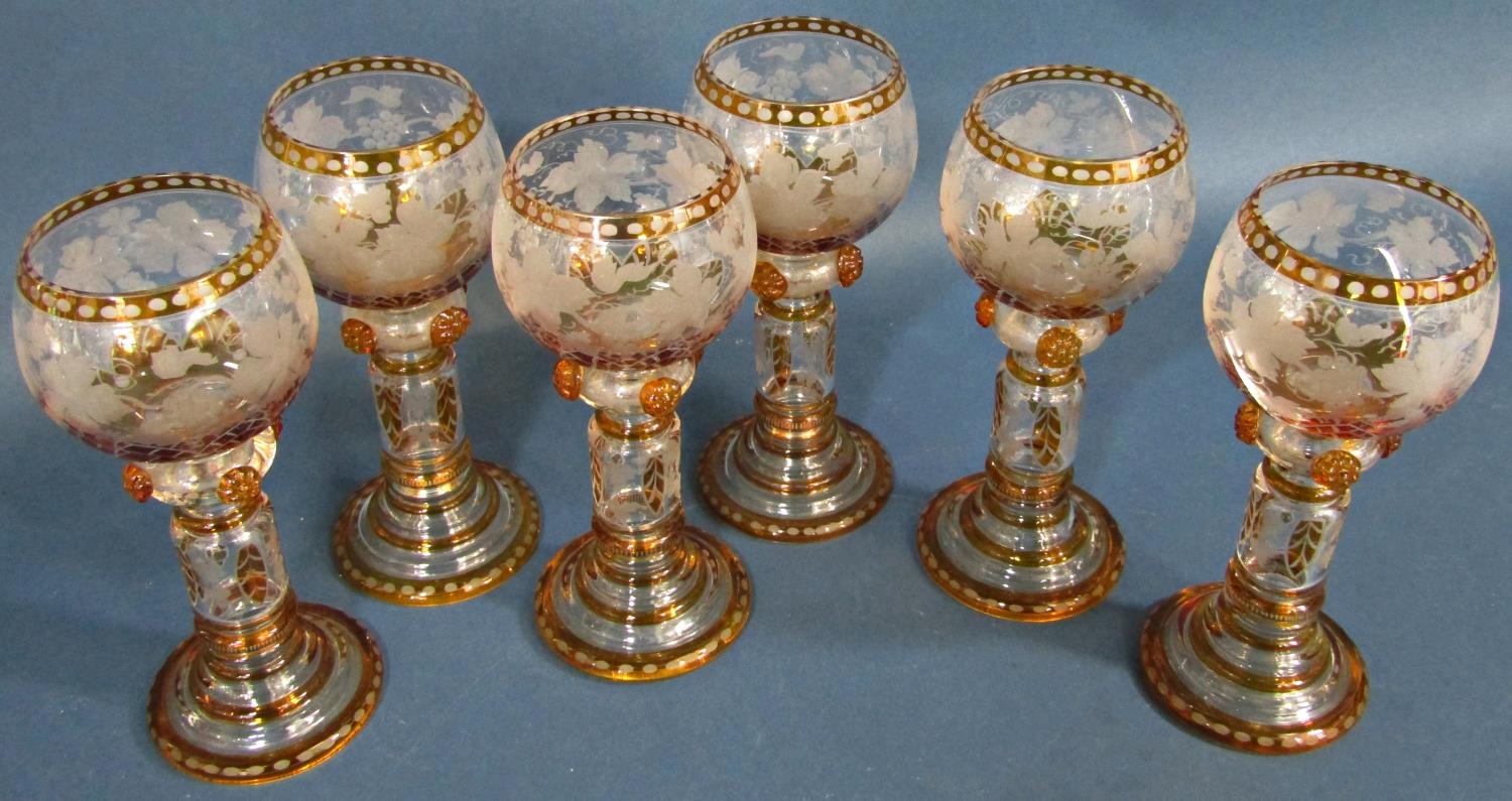 Six amber glass hock wine glasses with etched vine leaf decoration, five cut glass wine glass, and a