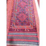 A Meshwani runner with a predominantly red and blue geometric pattern, 234cm x 57cm approx.
