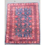 An East Turkoman silk rug with a large floral pattern on a blue ground, 193cm x 136cm approx.