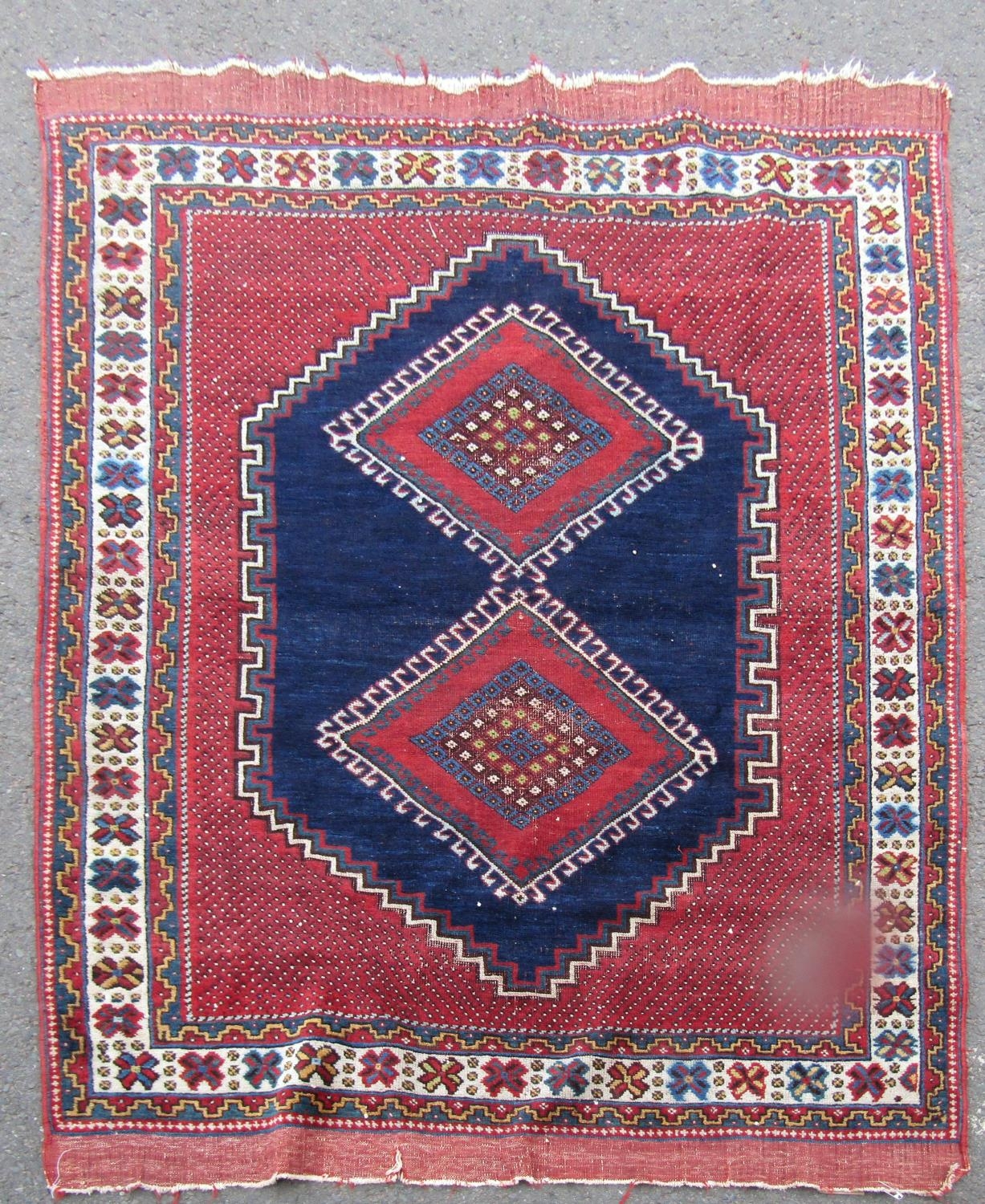 An Antique Persian Tribal carpet with two diamond medallions on a blue ground, 178cm x 120cm approx