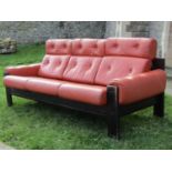 A contemporary three seat sofa with ebonised frame, upholstered and buttoned in leather, 2m wide
