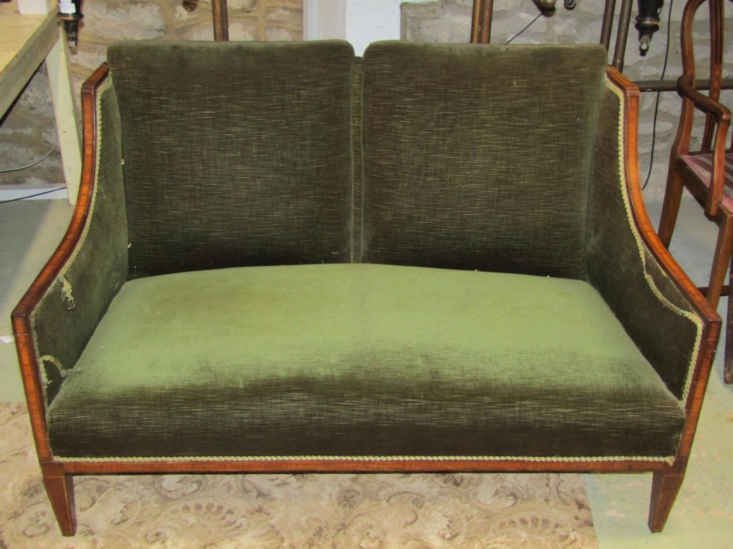 An Edwardian two seat drawing room sofa with green dralon upholstery, the mahogany frame with