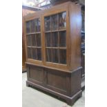 An early 20th century oak side cabinet, freestanding and enclosed by two pairs of panelled doors,