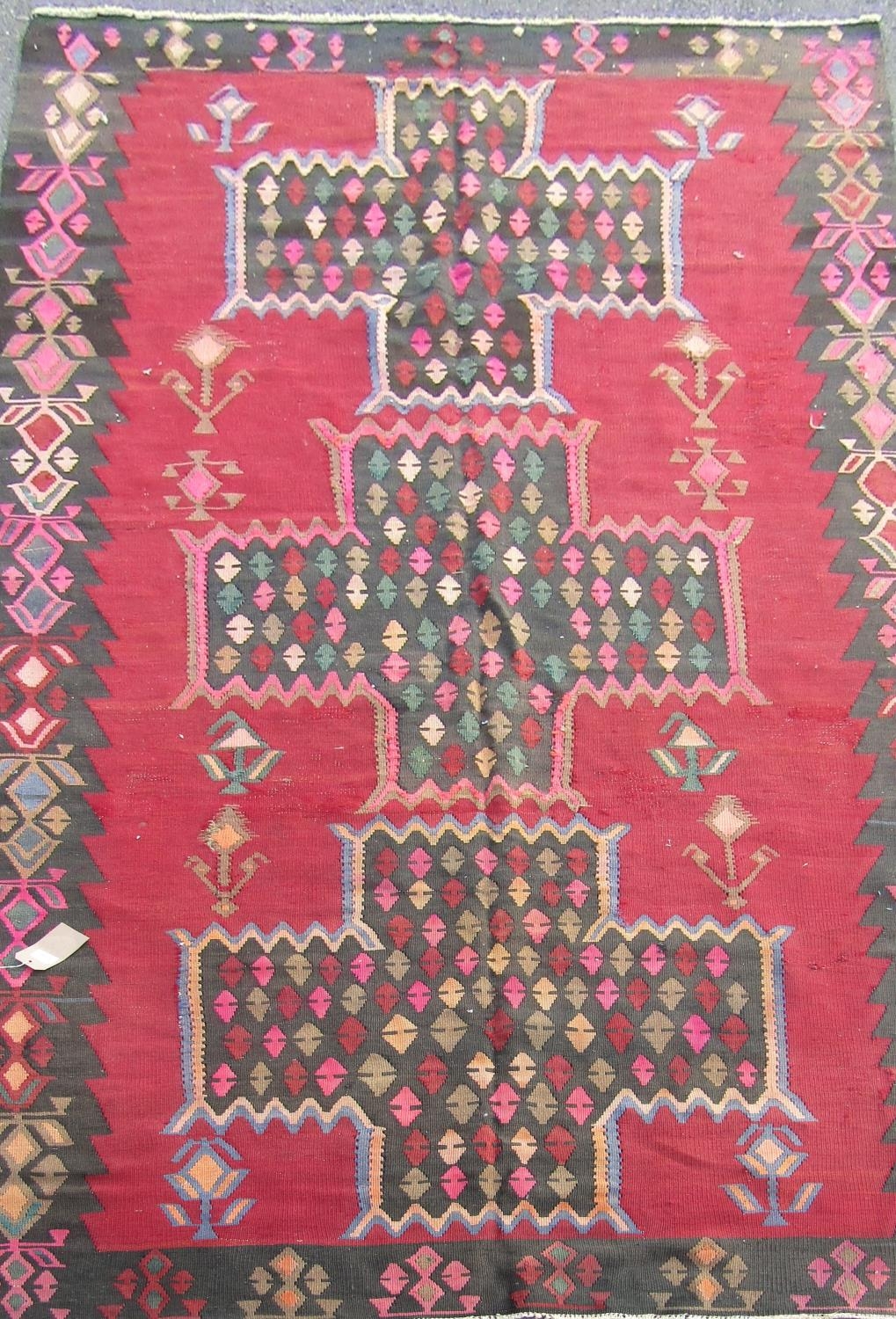 A South West Persian Qashgai Kelim, with a repeating all over pattern on a dark red field, 385cm x