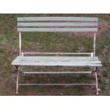 A painted and weathered iron framed folding two seat garden bench with painted wooden slats, (af),