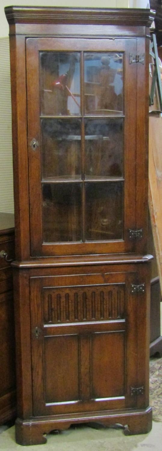 A good quality reproduction old English style oak freestanding two sectional corner cabinet labelled