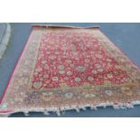 A Belgian machine made Persian style carpet with an all over floral pattern on a red ground, 360cm