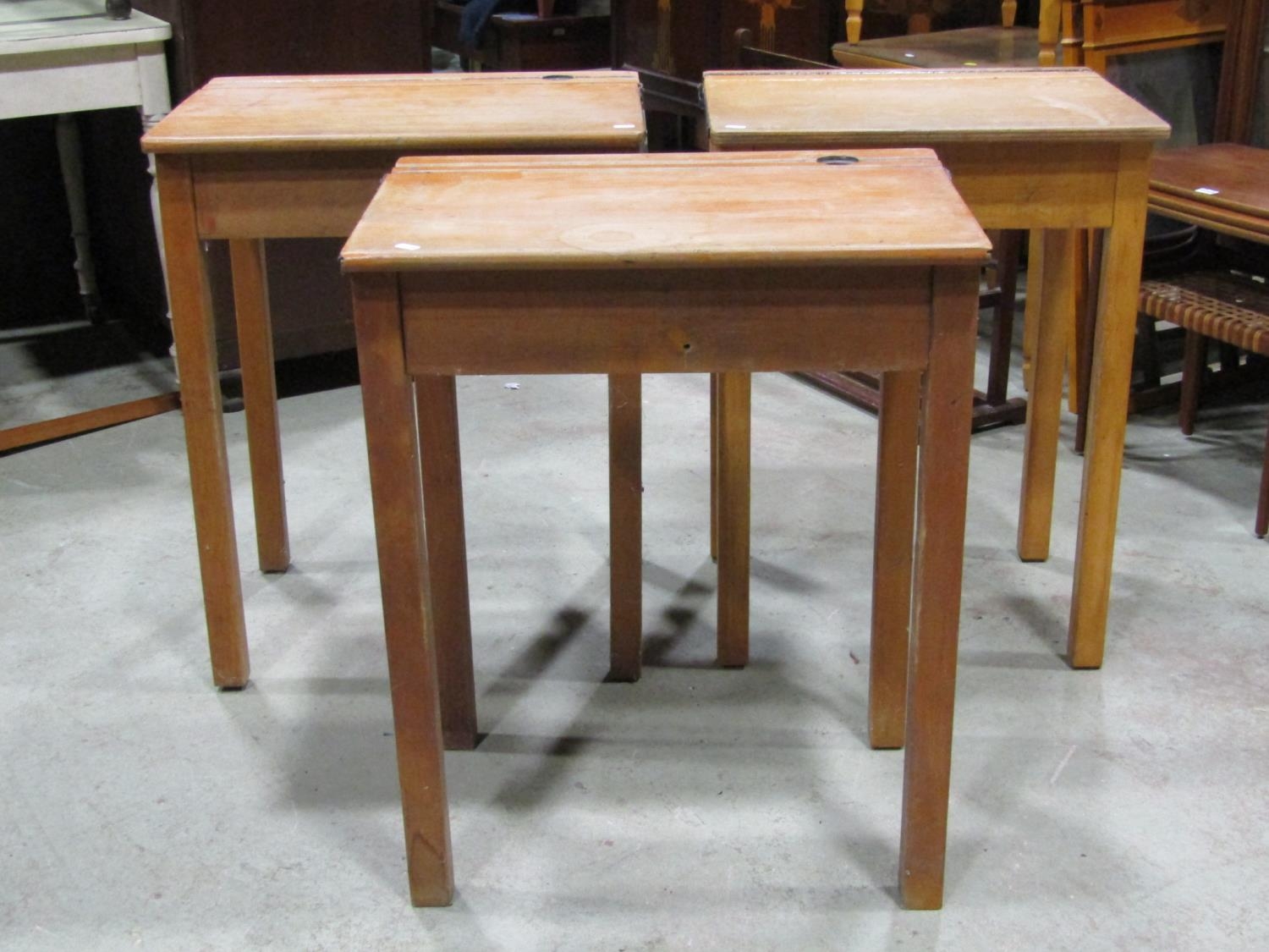 Three vintage beechwood school desks with hinged lids and metal fittings