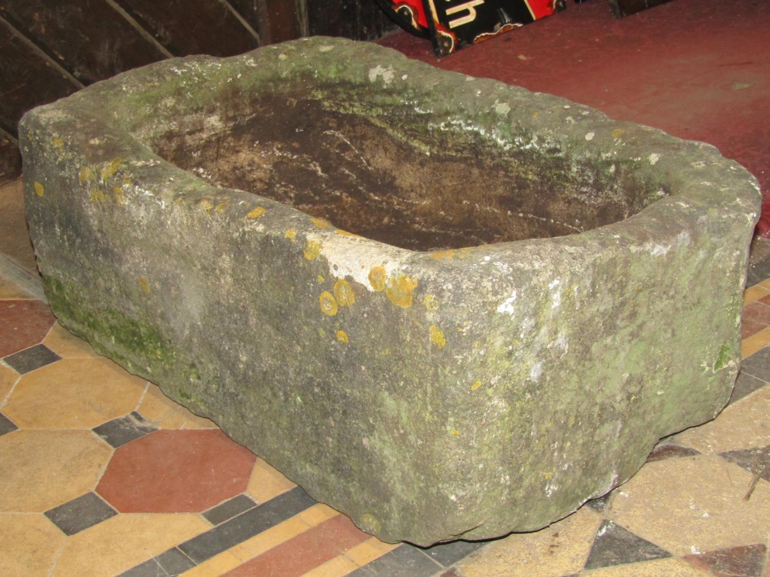 A weathered thick walled rectangular natural stone trough with circular drainage hole 76 cm long x