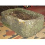 A weathered thick walled rectangular natural stone trough with circular drainage hole 76 cm long x