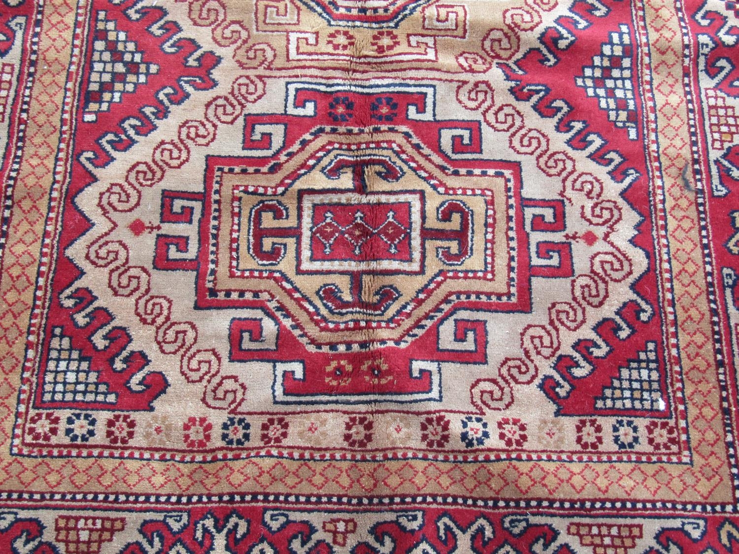 A Turkish Kazak Rug, with three hooked central medallions on a light brown field 189cm x 127cm, - Image 2 of 3