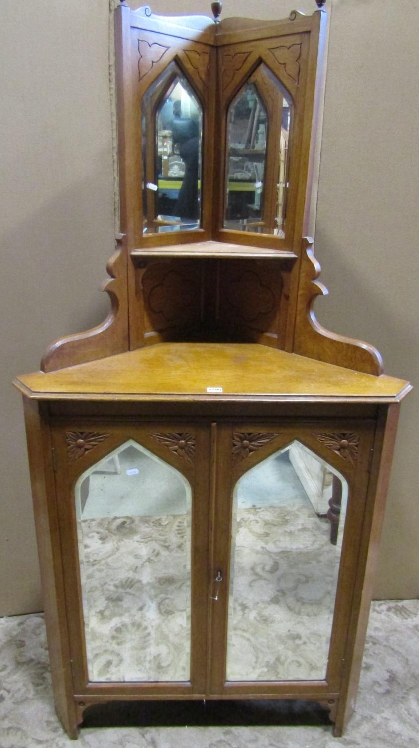 Victorian Gothic style light oak freestanding corner cabinet enclosing lancet shaped bevelled edge