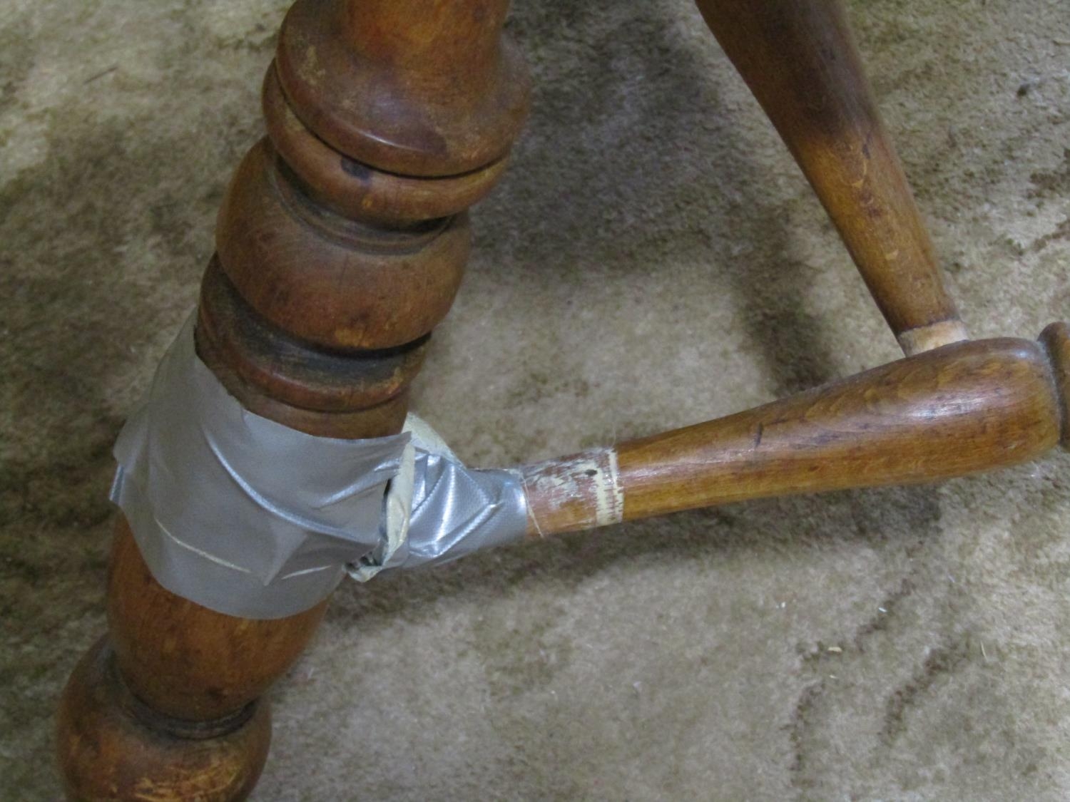 An antique Windsor smokers bow elbow chair in birch and stained beechwood raised on turned - Image 2 of 3