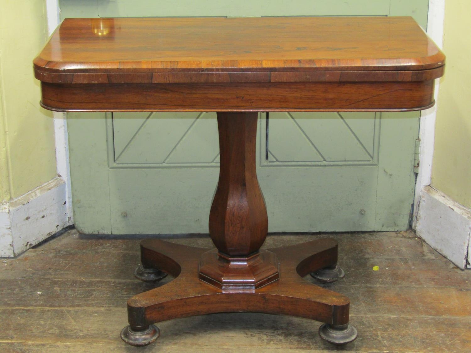 A late Regency rosewood D end fold over top card table with vase shaped pillar and platform base