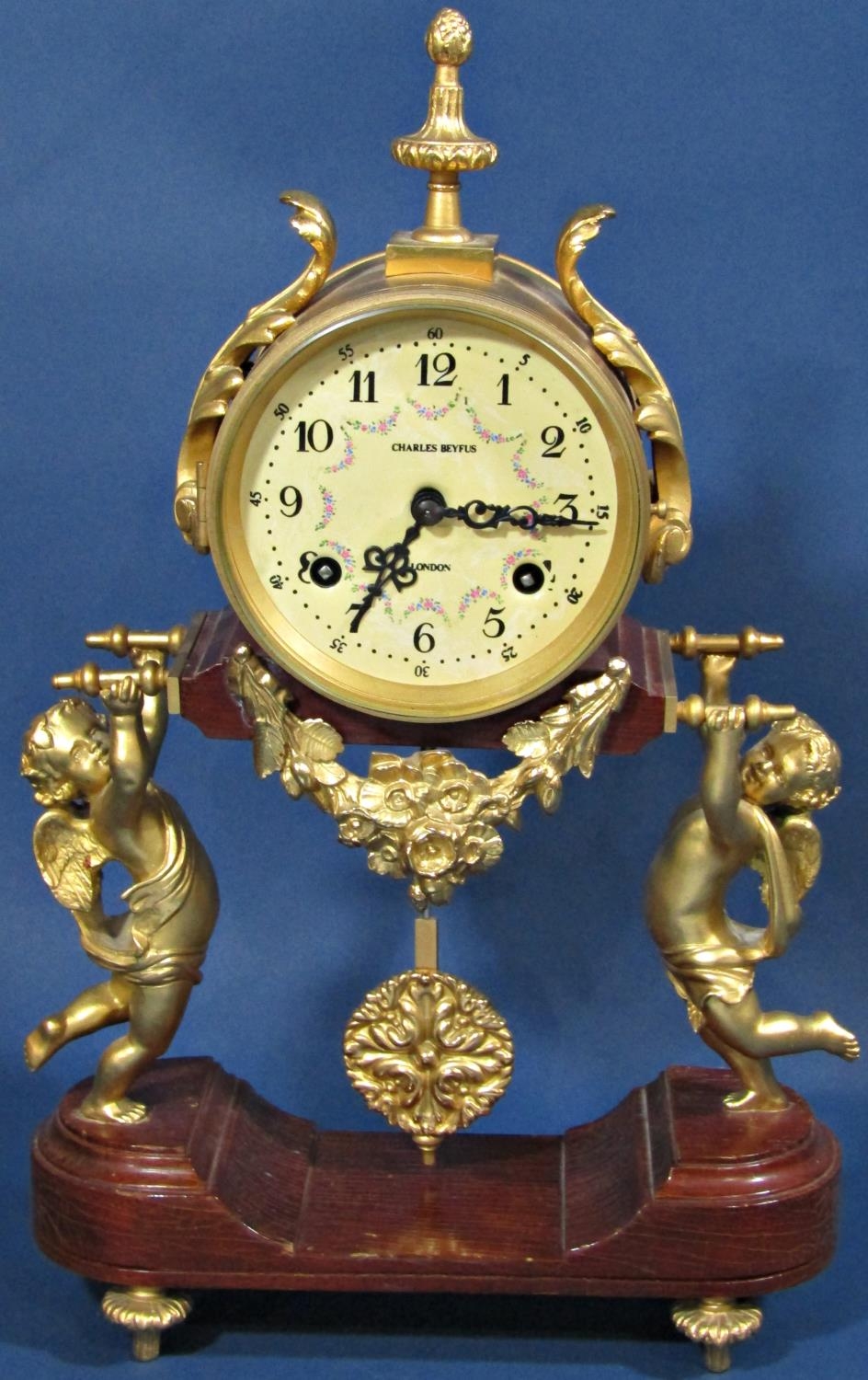 A contemporary mantle clock, the movement held aloft by two cherubs, with painted dial - Charles