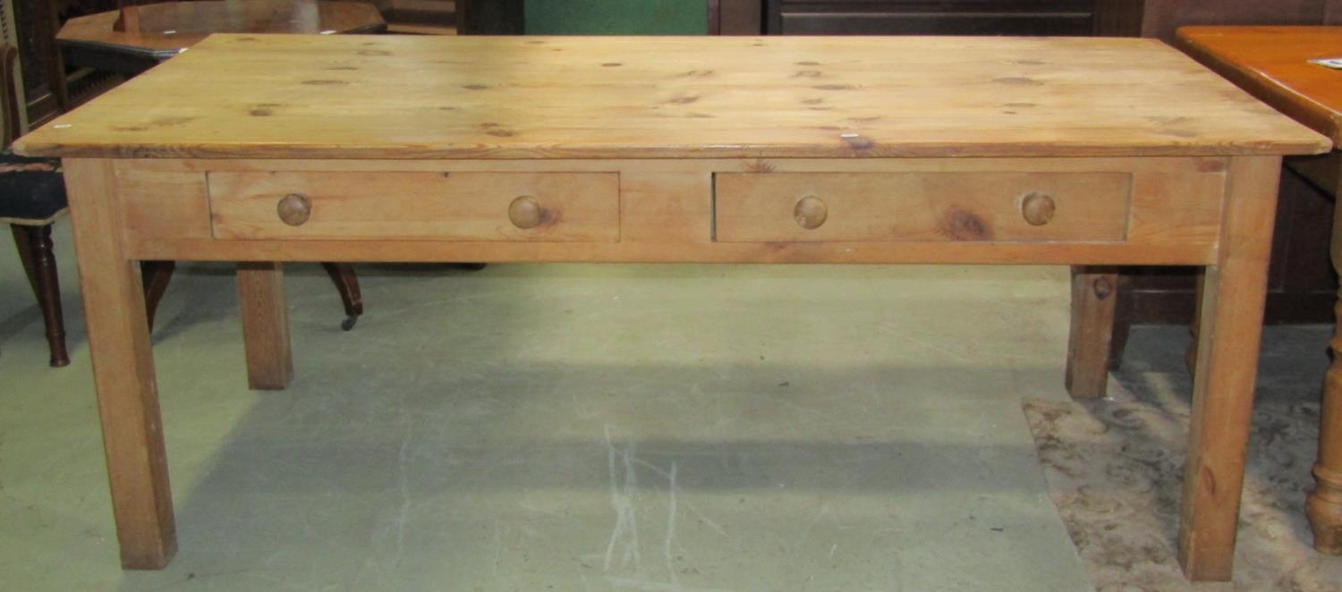 A stripped pine farmhouse kitchen table with rectangular planked top over two frieze drawers