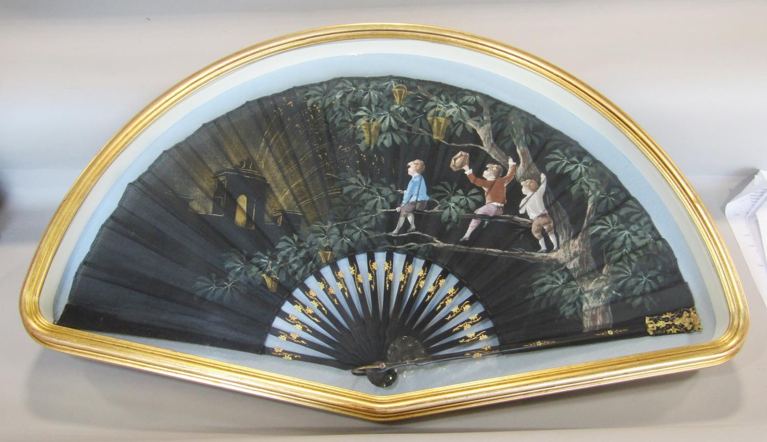 A late 19th century French fan on satin with ebony sticks, with painted detail showing three boys at